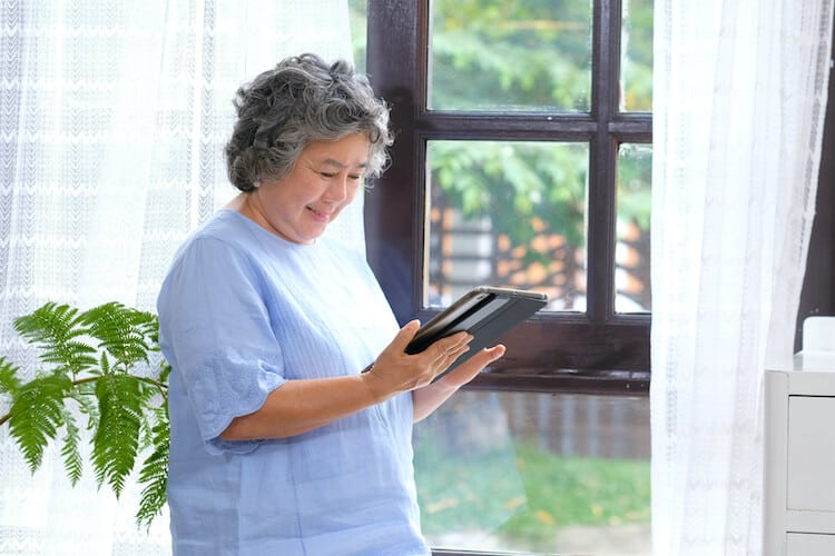 A senior woman using a tablet in her retirement community