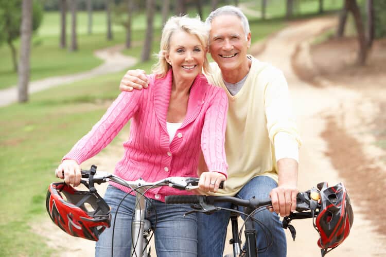 Senior couple riding bicycles on a trail.
