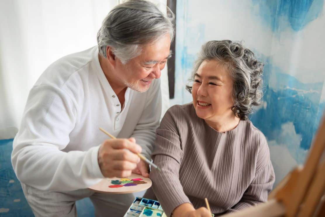 A senior couple enjoying the art studio, one of the many benefits of senior living.