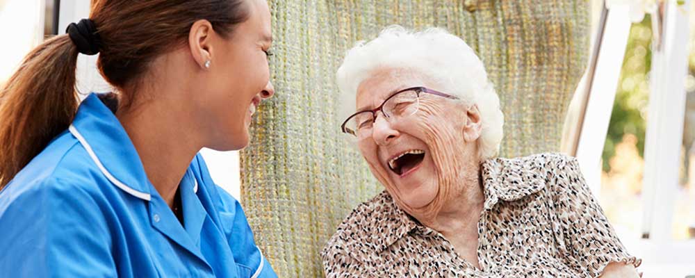 Senior woman in memory care speaking with nurse cropped