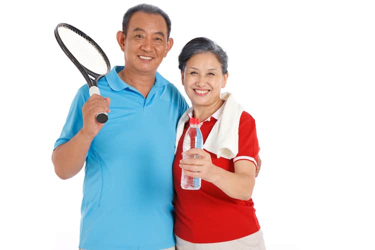 senior couple holding racket and water