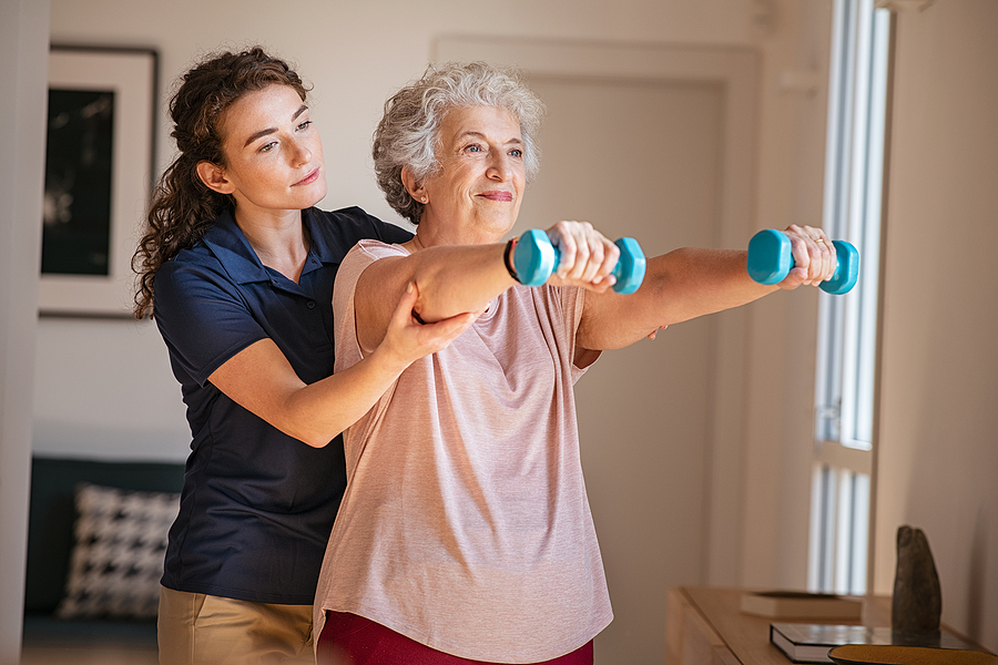 Senior woman in rehab with a therapist helping