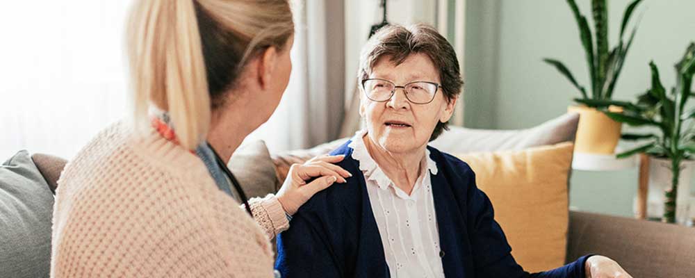 Senior woman in assisted living with caretaker cropped