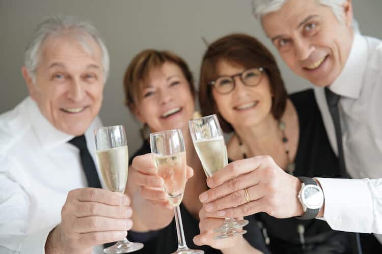 Group of senior friends cheering with champagne.