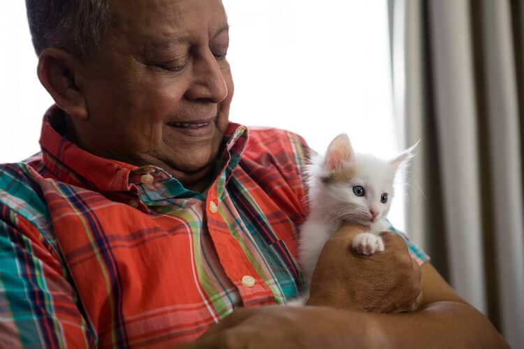 Happy senior holding a kitten.