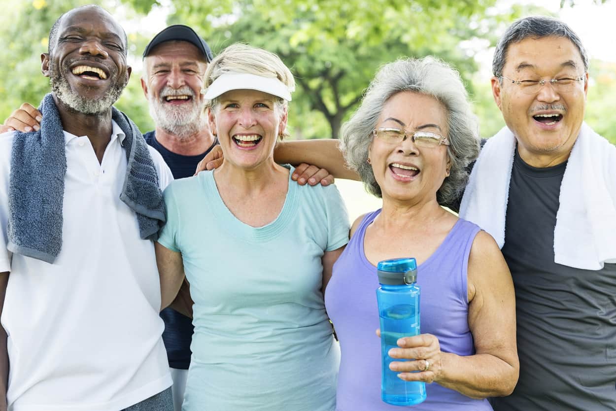 senior friends finishing an exercise class, outside and taking a photo
