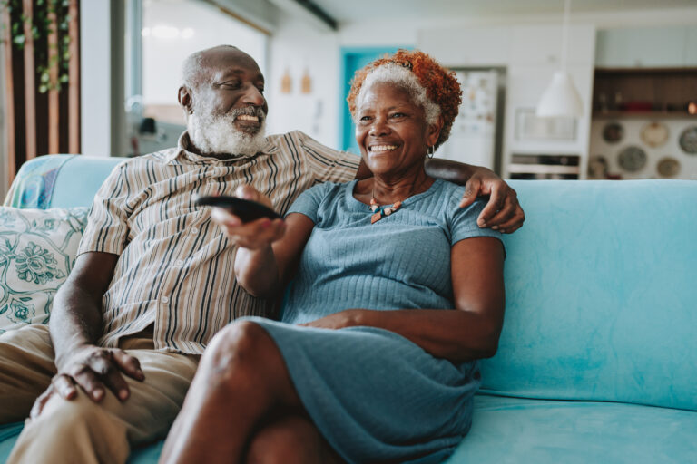 senior couple watching TV in living room