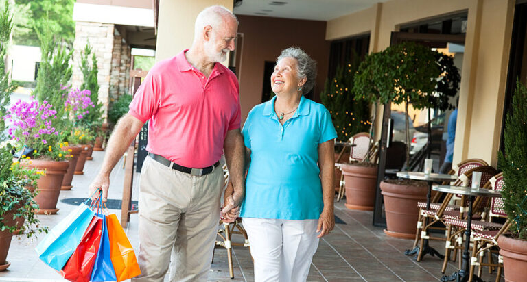Senior woman on a shopping spree looks up at her handsome husban