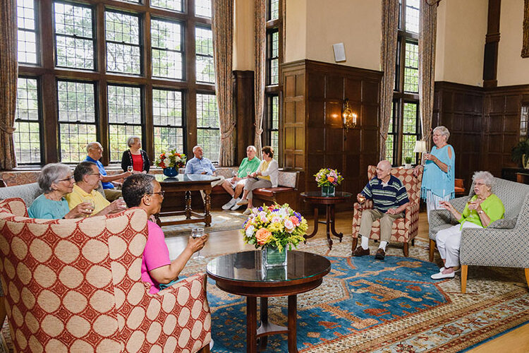 Group of seniors in common room, gathered around, having a conversation