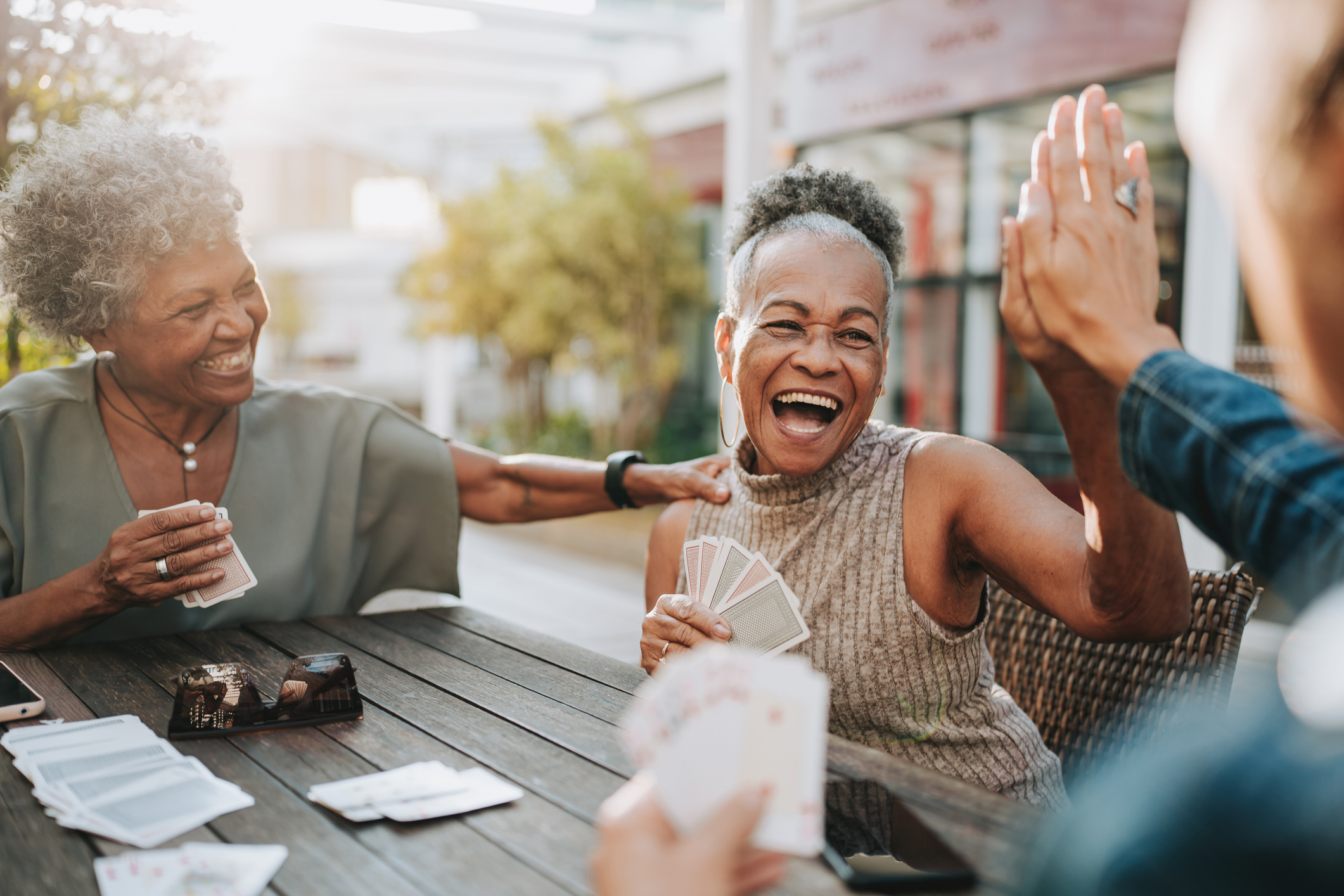 A group of senior women friends playing cards and laughing