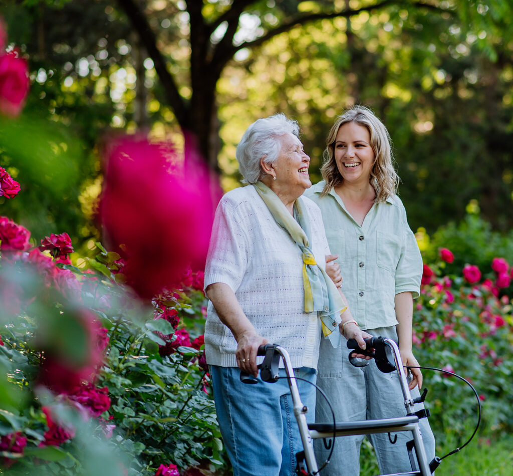 Adult granddaguhter supporting her senior grandmother when taking her for walk